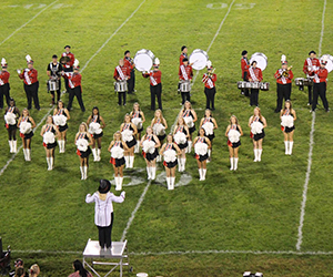 Band members and cheerleaders perform on a field