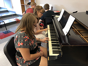 Female students playing the piano in the music appreciation class